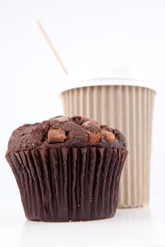 Chocolate muffin and a cup of coffee placed together against a white background