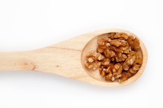 Wooden spoon with nuts against a white background