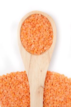 Wooden spoon with lentils against a white background