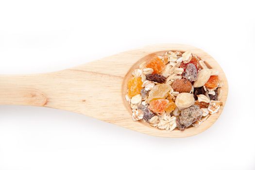 Wooden spoon with muesli  against a white background