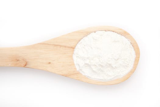 Wooden spoon with flour against a white background