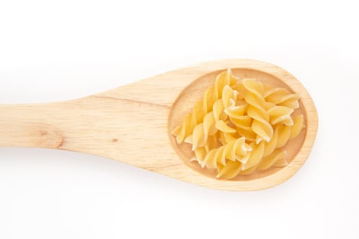 Wooden spoon with pasta  against a white background