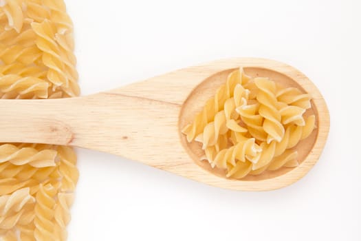 Wooden spoon with pasta  against a white background