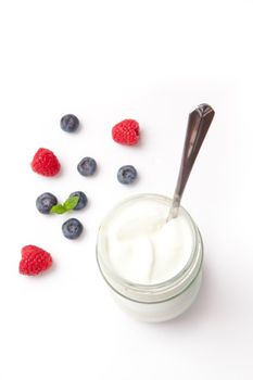 Yogurt and berries against a white background