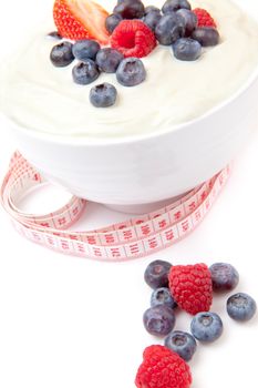 Different berries cream with a tape measure  against a white background