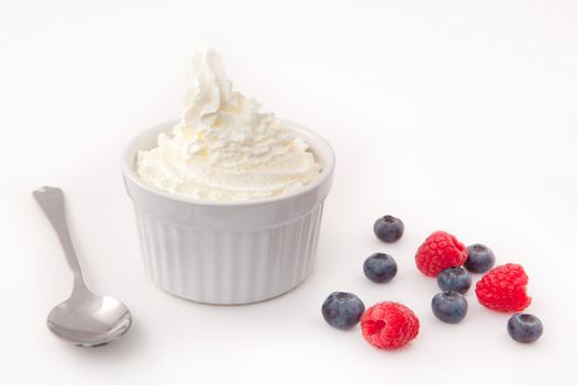 Whipped cream with berries against a white background