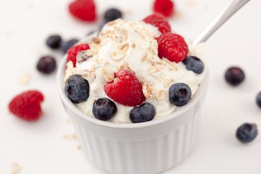 Sweet berries in whipped cream against white background