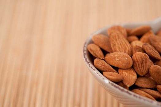 Roasted almonds in a bowl on a wooden placemat