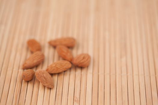 Eight almonds laid out together on a wooden placemat
