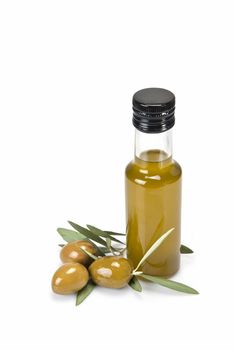 Glass bottle of premium virgin olive oil and some olives with leaves isolated on a white background