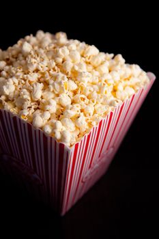 Close up of a box of pop corn against a black background