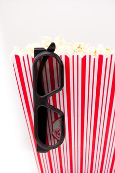 3D Glasses hanging on a striped box full of popcorn