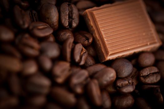 Close up of a piece of chocolate and coffee seeds together