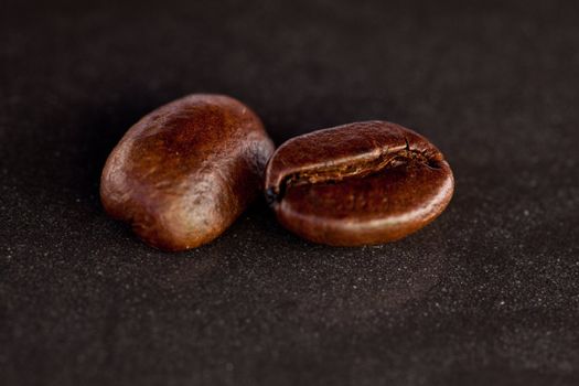 Two coffee seeds on a black table
