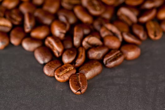 Many blurred coffee seeds laid out together on a black table