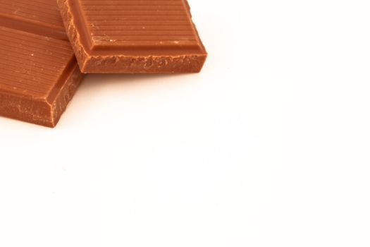 Two pieces of milk chocolate against a white background 