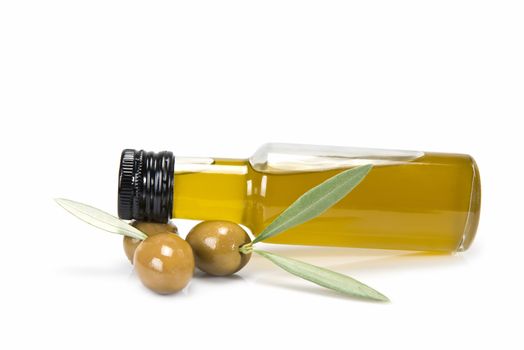 Glass bottle of premium virgin olive oil and some olives with leaves isolated on a white background