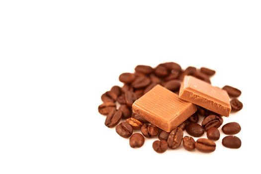 Two pieces of chocolate on coffee seeds against a white background