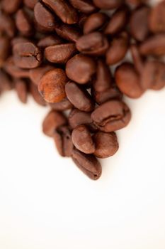 Blurred seeds of coffee laid out together against a white blackground