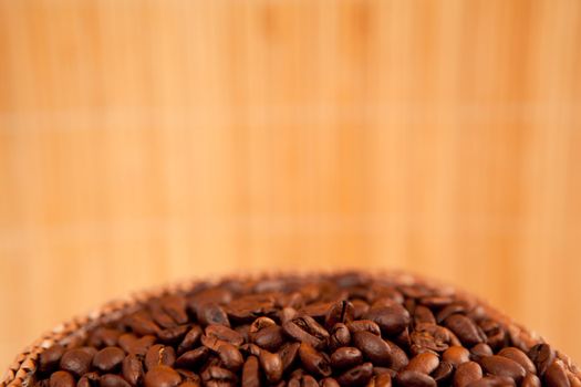Close up of the top of a basket full of roasted coffee seeds