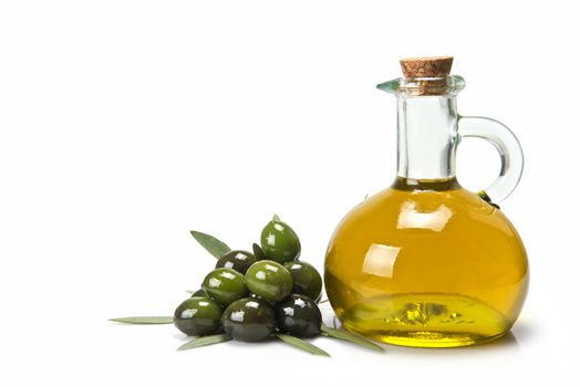 Glass bottle of premium virgin olive oil and some olives with leaves isolated on a white background