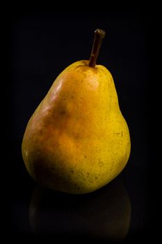 One fresh Pear on black background with reflection