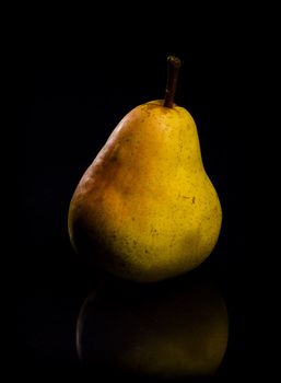 One fresh Pear on black background with reflection