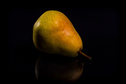 One fresh Pear on black background with reflection