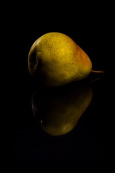 One fresh Pear on black background with reflection