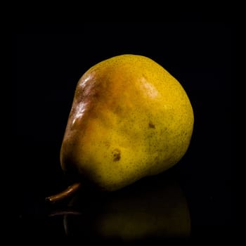 One fresh Pear on black background with reflection