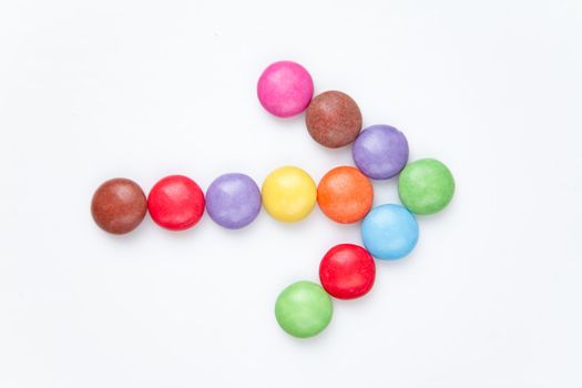 Arrow of candies against a white background