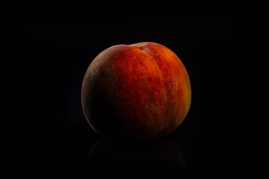 One fresh Peach on black background with reflection