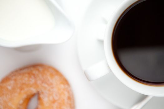 Espresso with doughnut against a white background