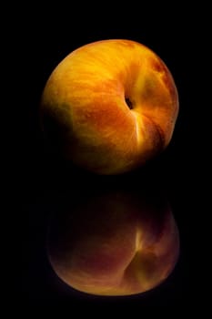 One fresh Peach on black background with reflection