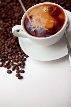 Black coffee and milk  with beans against a white background