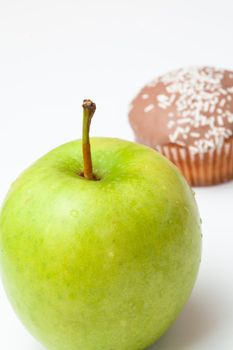 Muffin and apple against a white background