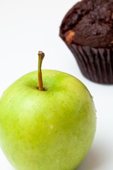 Apple and muffin against a white background