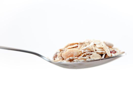 Spoon with muesli on a white background