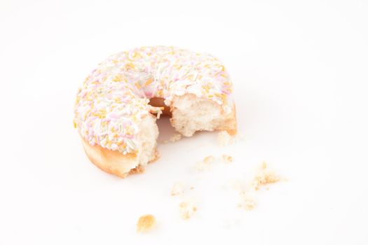 Sugar doughnut with crumbs against white background