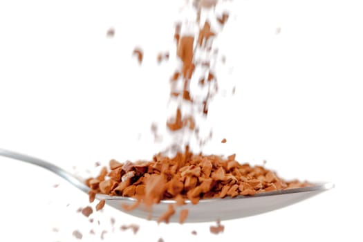 Chocolate powder falling in a spoon against white background