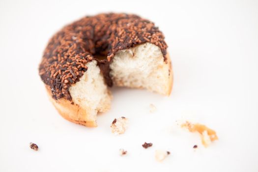 Chocolate doughnut with crumbs against grey background