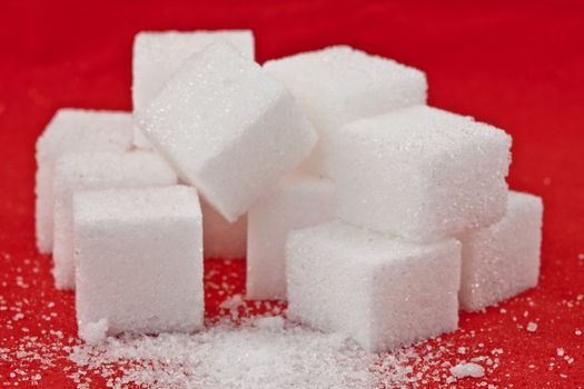 Stack of sugar  against a red background