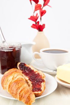 Table presentation with croissant spread with jam indoors