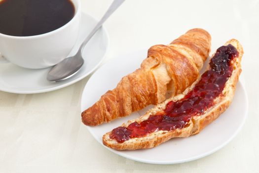 Croissant next to a coffee cup on a table