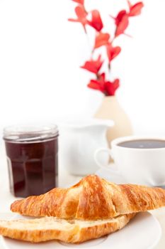 Breakfast with a bisected croissant  against white background