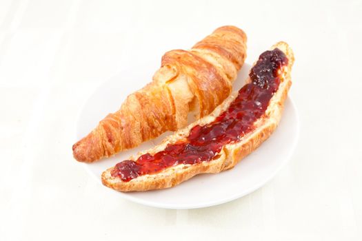 Croissant on a plateful against white background