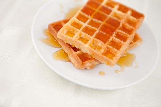 Waffles spread with honey on a table