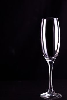 Empty champagne flute against black background