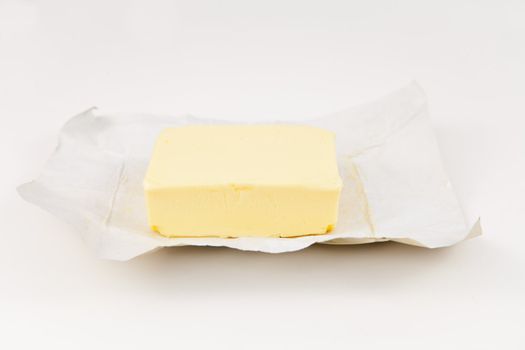 Open pat of butter against white background