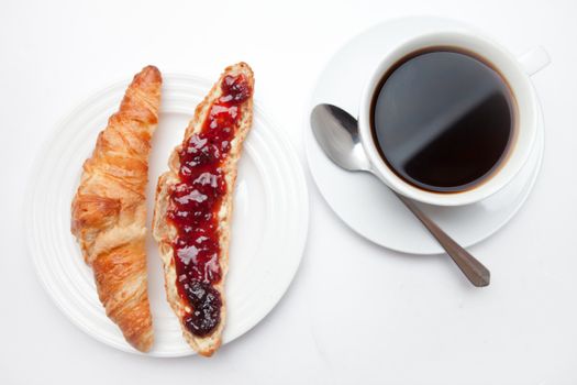 Coffee mug placed next to a croissant on a table